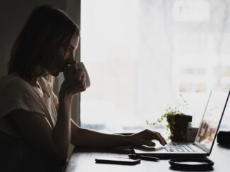Dame drikker kaffe og arbejder