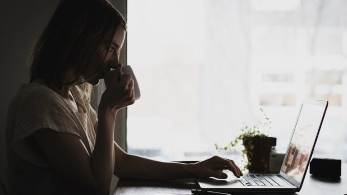 Dame drikker kaffe og arbejder Dame drikker kaffe og arbejder