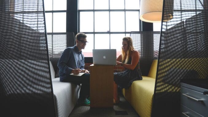 To personer taler sammen på arbejdet To personer taler sammen på arbejdet